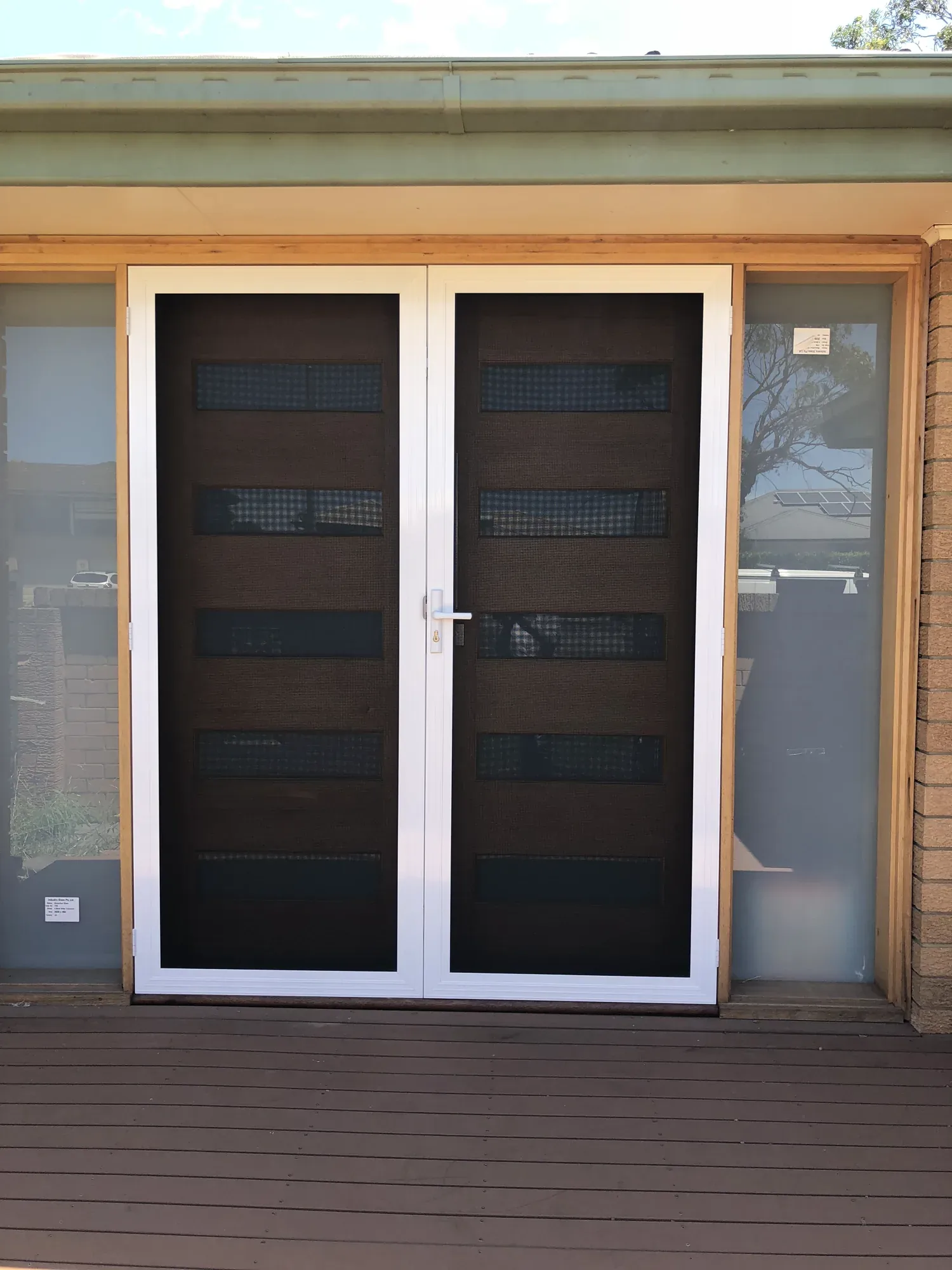 Pair of black double security screen doors with white frames fitted to a home entrance.