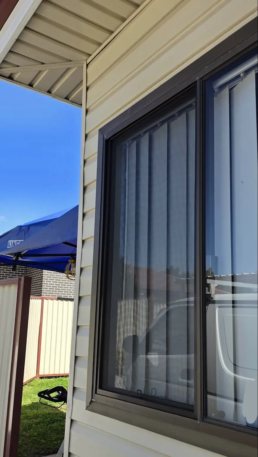 Black sliding flyscreen fitted to the exterior of a residential window.